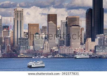 Seattle Skyline. A lovely spring day along the Seattle, Washington waterfront. This view across Elliott Bay pictures puffy clouds and ferryboats with modern office buildings in the background.