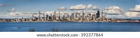 Seattle, Washington Panorama.  A lovely spring day along the Seattle, Washington waterfront. This panoramic view features puffy clouds, ferryboats, the Space Needle, and modern office buildings. 