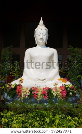 White buddha statue with flowers
