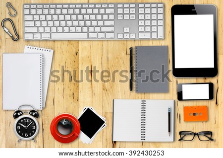 Top view desks with smart phone, keyboard, pencil, coffee mug, glasses, photo paper, Cassette Tapes and other business supplies.