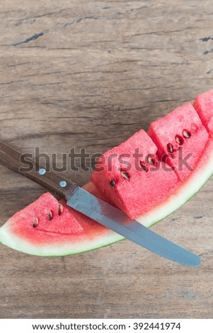 Slices watermelon with knife on wooden background