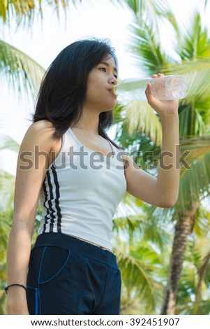 Asian sport woman drinking water form bottle
