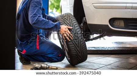 Inside a garage - changing wheels/tires (shallow DOF; color toned image) Royalty-Free Stock Photo #392475040