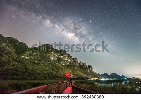 Night photography of a man standing against milky way and mountain in Khao Sam Roi Yot national park, Thailand