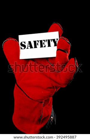 worker holding a card  with the inscription SAFETY 