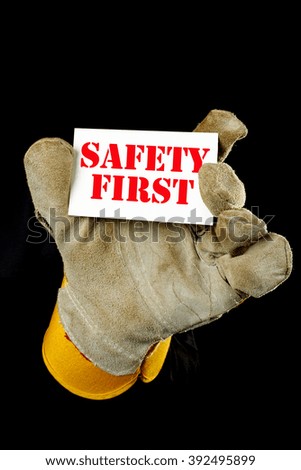 worker holding a card  with the inscription SAFETY FIRST
