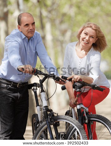 Smiling elderly couple with bicycles on summer vacation