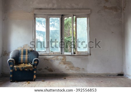 Armchair in an abandoned building Royalty-Free Stock Photo #392556853