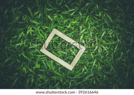 wooden frame on green grass background