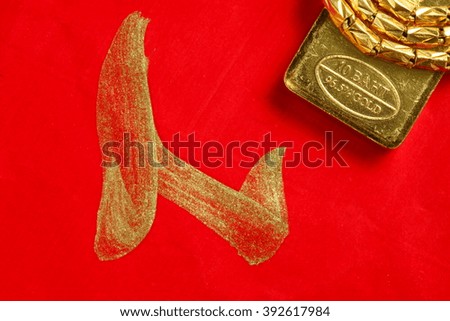 The gold bar put on the red color paper with chinese letter written from chinese brush as a background  represent the wishes concept related idea.