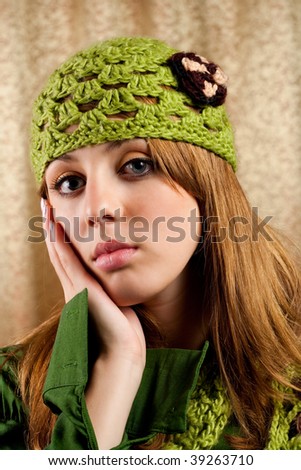 Portrait of a beautiful blonde in retro cap and scarf over shiny curtain background