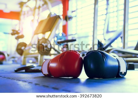 Red And Blue boxing gloves hanging on a Blue wall IN Gym Fitness  Royalty-Free Stock Photo #392673820