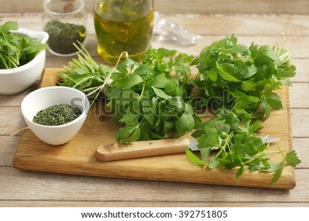 Lovage on wooden board, dried lovage in a small bowl and lovage infused oil Royalty-Free Stock Photo #392751805