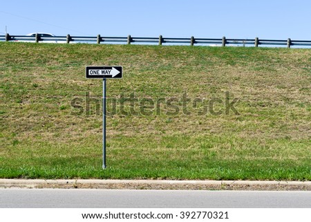 one way sign with a grassy background