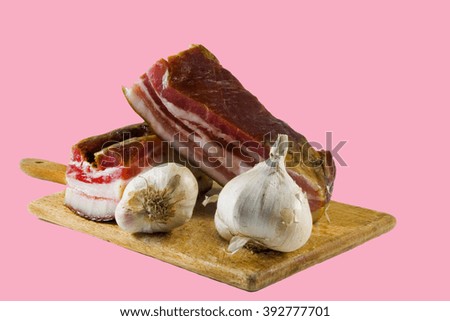 Bacon with garlic and knife on wood cutting.                               