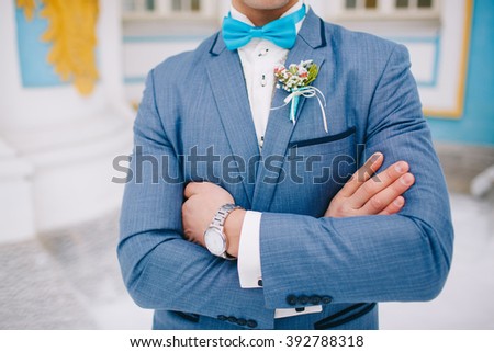 The crossed arms of the groom closeup