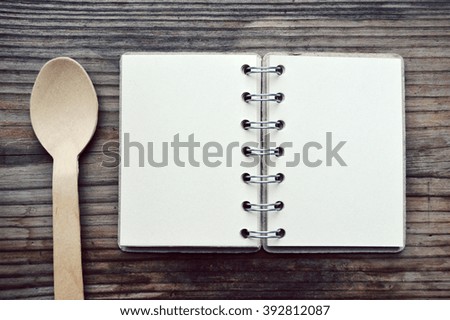 An empty retro spiral notebook with wooden spoon