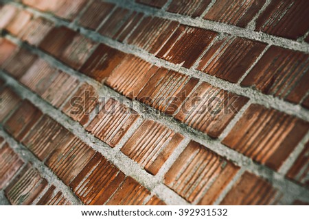 Grunge aged and weathered red brick wall surface texture close up with shallow depth of field as background image