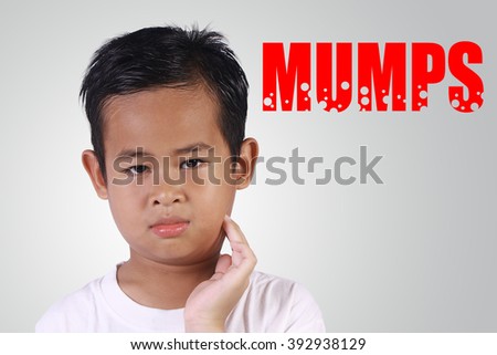 Healthcare and medicine. Asian boy with mumps disease touching his swollen cheek Royalty-Free Stock Photo #392938129
