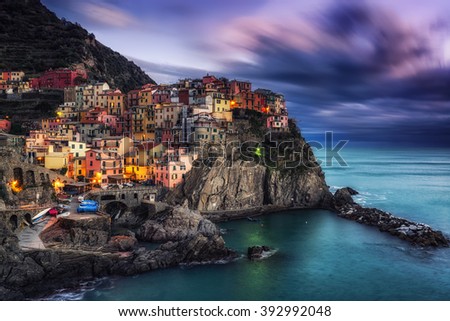 beautiful sunset over manarola in cinque terre, Italy. Sunlight lighting up the tips of the stormy clouds just before the night dawned. Manarola is a small coastal town in cinque terre, Italy.