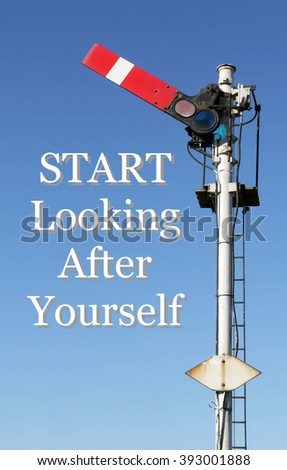 Historic red home British railway signal in the start position with an Inspirational motivational quote of Start Looking After Yourself against a clear blue sky background.