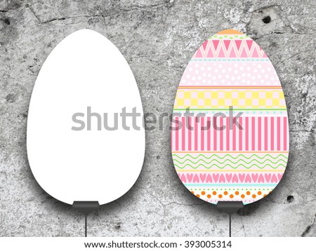 Close-up of two hanged Easter egg frames with clips against grey concrete wall background