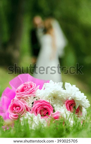 Bridal bouquet on a background of blurred silhouette of a bride with the groom.
