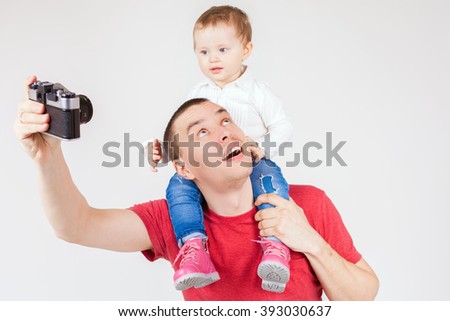 Image of funny father and child making selfie at vintage old camera. Family. White background. Fashion baby. Looking at camera. Hobby.