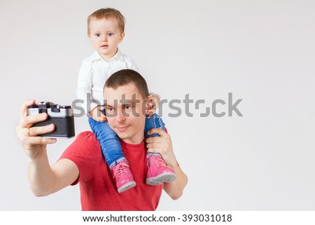 Image of funny father and child making selfie at vintage old camera. Family. White background. Fashion baby. Looking at camera. Hobby.