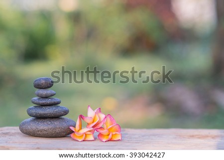 frangipani flower and stone zen spa on wood with garden blurred background