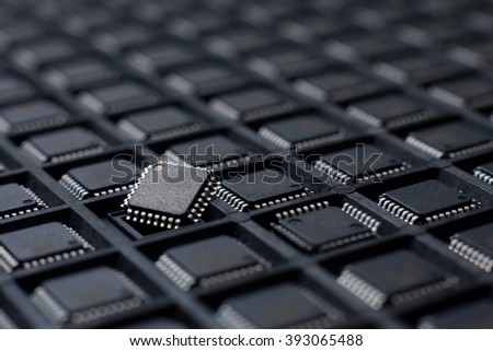 Pallet of microcontrollers in a TQFP housing. Electronic components and chip manufacturing. Many rows of processors Royalty-Free Stock Photo #393065488