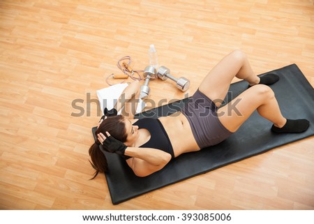 High angle view of a young athletic woman in sporty outfit doing crunches at the gym with a lot of copy space