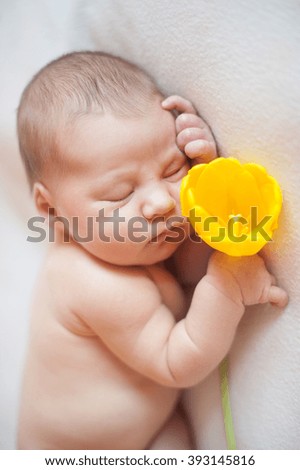 vertical pictures - baby girl sleeping with yellow tulips in a hand