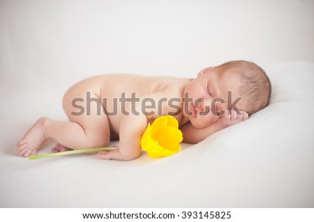 horizontal pictures - baby girl sleeping with yellow tulips in a hand