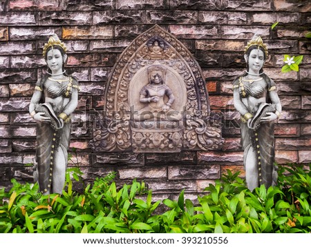 Ancient two angel blick wall and green plant background