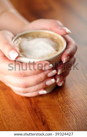 Cup of White Coffee with frothed milk in woman's hands