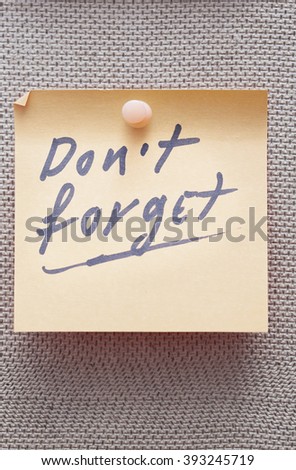 Adhesive note with Do not forget text on a bulletin board