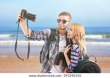 Young couple of travelers taking selfie on the sea background