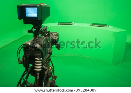 Television studio with camera and lights - camera on green screen