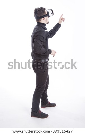 Young man using virtual reality glasses while pointing fingers at something Royalty-Free Stock Photo #393315427