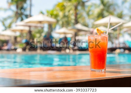 Cocktail glasses at pool, beach side. Royalty-Free Stock Photo #393337723