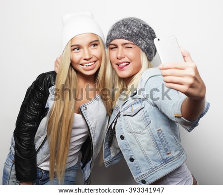 Two teenage girls friends in hipster outfit make selfie 