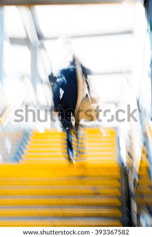 People walking up to stairs, abstract background blur
