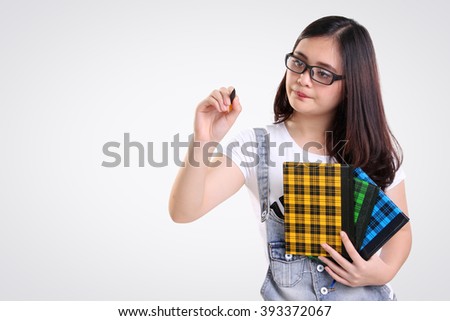 Nerdy female student gestures writing on the screen with a pen, isolated on white background