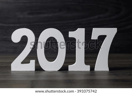 White word of 2017 on black wooden background.
