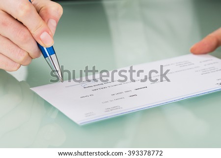 Close-up Photo Of Businesswoman Hand Signing Cheque