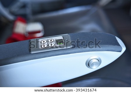 Airplane entertainment display on an arm rest inside the plane.  Royalty-Free Stock Photo #393431674