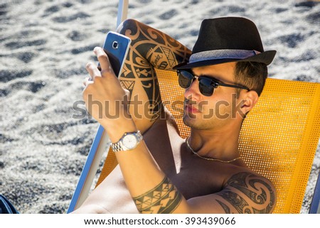 Young man lying on deckchair at beach