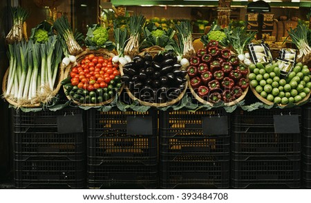 Harvest in baskets presented outside market sale tomatoes leek zucchini cabbage garlic eggplants bell peppers italian peppers Black chalk board price tags slightly unfocused perfect as background