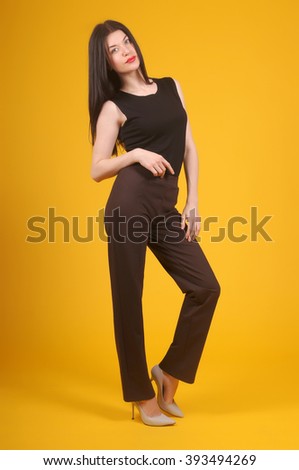 Beautiful young girl posing in street clothes on yellow background.Isolated studio portrait